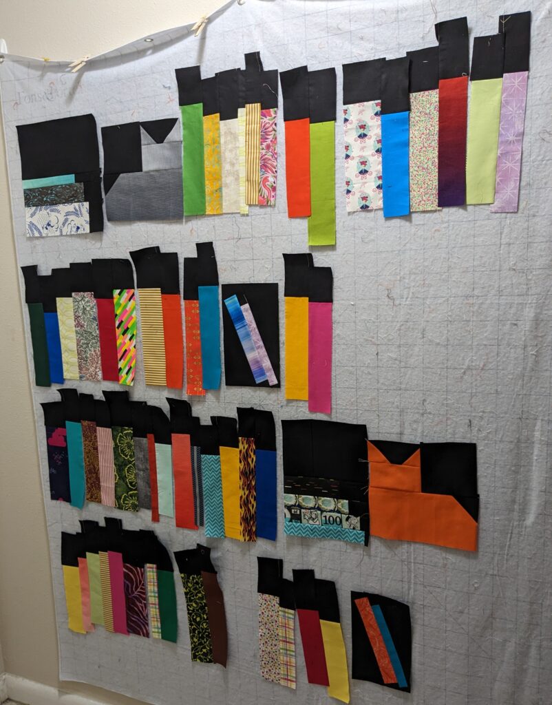 Blocks for the bookcase quilt being laid out on the design wall prior to being sewn together.