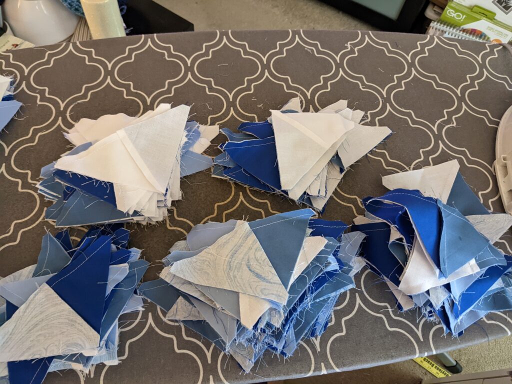 My ironing board with blue and white fabric triangles on top.