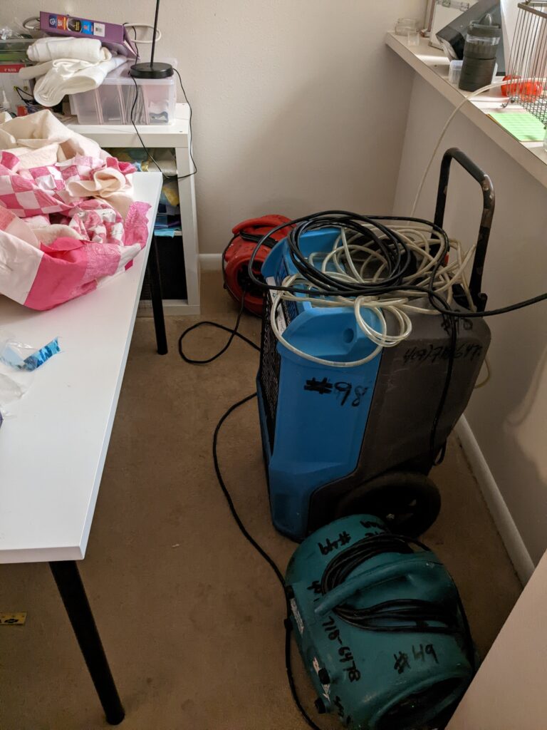 A dehumidifier and two blowers on the carpet in my dining room.
