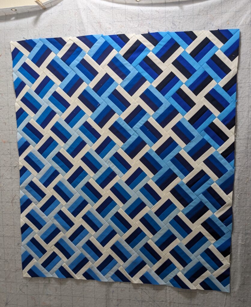 The fully sewn quilt top laid out on my design wall.