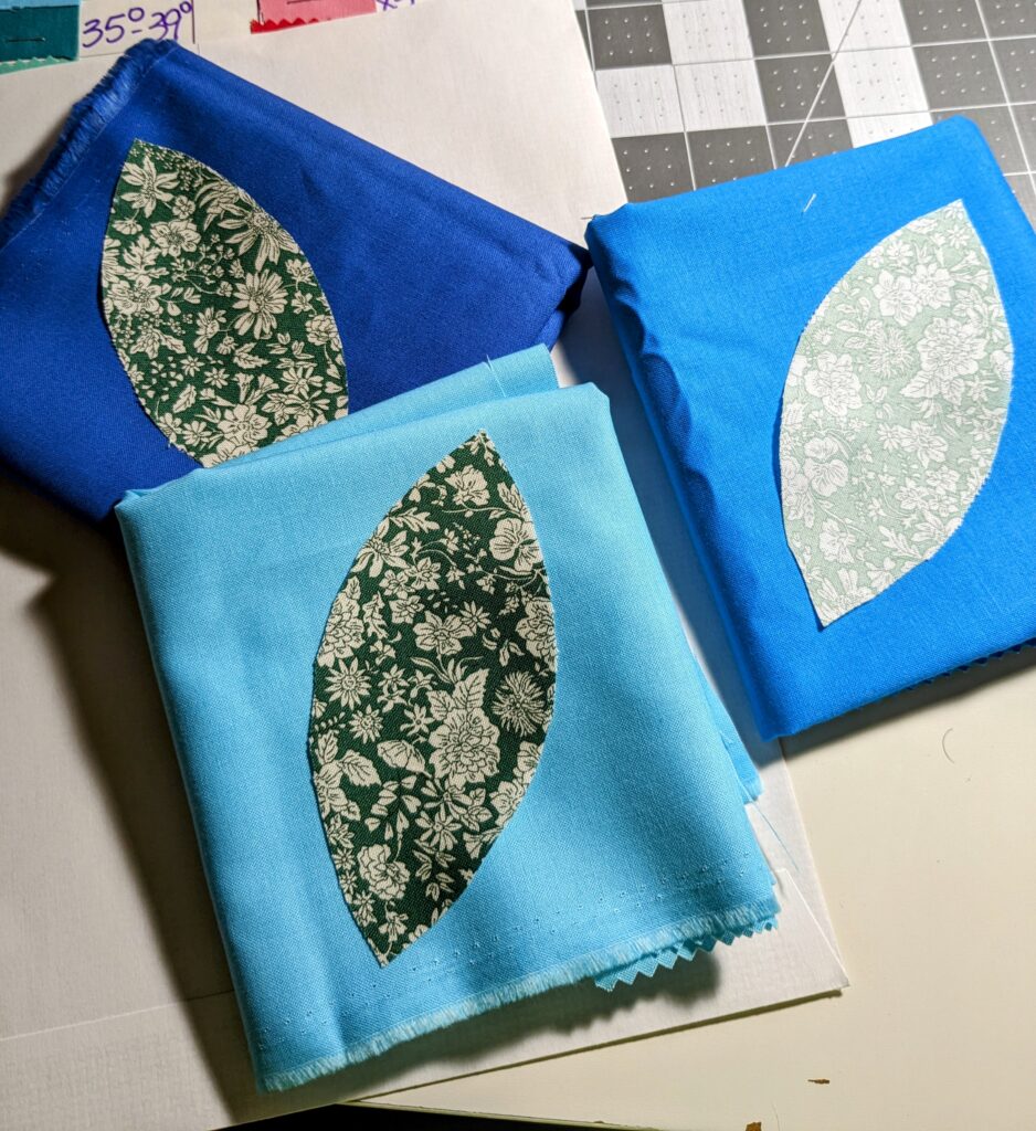 Orange peel petals cut out of Liberty fabric laid on top of solid fabrics.