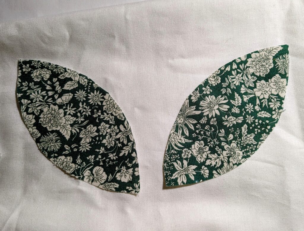 Orange peels from Liberty fabric laid on top of white fabric.