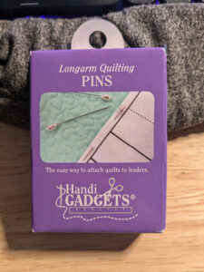 A purple box of longarm quilting pins from HandiQuilter.